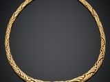 un collier en or avec un motif tressé sur fond noir
