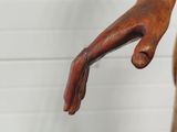a wooden statue of a hand holding something in it ' s right hand