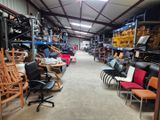 des rangées de chaises et de tables dans un entrepôt rempli de meubles