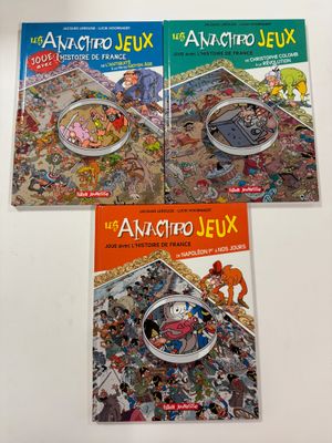 trois livres pour enfants posés sur une table blanche, avec une loupe à côté