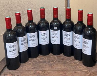 six bouteilles de vin rouge sont alignées sur une table en bois