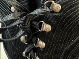 a close up of a black belt with silver buttons on it
