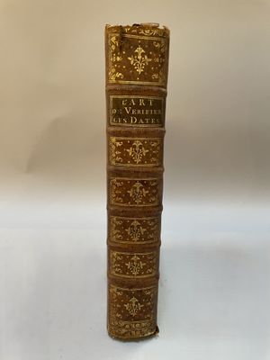 un vieux livre posé sur une table blanche à côté d'un mur blanc