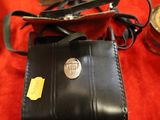 a small black wallet with a metal button on it