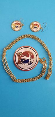 un collier, des boucles d'oreilles et une pièce de monnaie sur un fond bleu