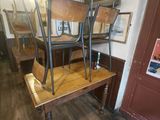 a wooden table with four chairs on it in a room