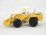 a yellow toy truck that is sitting on a white surface