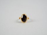 une bague en or sertie d'une grosse pierre noire
