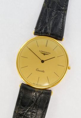 a close up of a watch on a white surface with a black strap