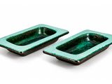 pair of green ceramic ashtrays on a white background