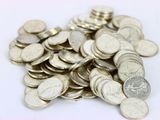 une pile de pièces d'argent sur une surface blanche