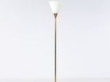 un lampadaire en laiton avec un abat-jour en verre blanc