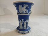 un vase bleu posé sur une surface blanche