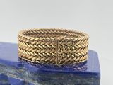 un gros plan d'une bague en or posée sur un bloc de marbre bleu
