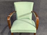 a chair with a green upholstered seat on a gray carpet