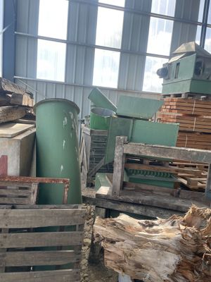 un tas de bois dans un entrepôt, avec une machine en arrière-plan
