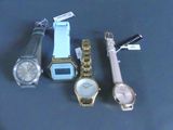 trois montres et un stylo posés les uns à côté des autres sur une table