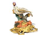 a figurine of a bird sitting on top of a pile of pumpkins
