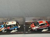 two miniature cars in a display case on a table