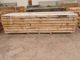 several pieces of wood are stacked on pallets in a warehouse