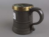 a black mug with a gold rim sitting on a table