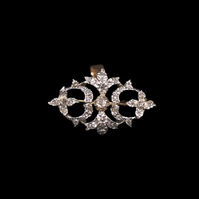 un gros plan d'une broche en diamant sur fond noir