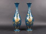 pair of blue and gold vases sitting on top of a table