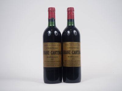 deux bouteilles de vin posées l'une à côté de l'autre sur une surface blanche