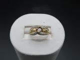 an image of a gold and silver ring on top of a white ring holder