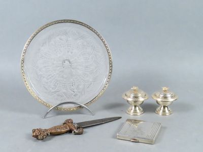 un plateau en argent avec un couteau et d'autres objets posés sur une table