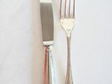 deux fourchettes et un couteau sur une table blanche