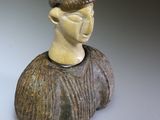 a ceramic sculpture of a man with a hat on his head