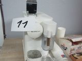 une cafetière posée sur une table, avec une boîte de café devant