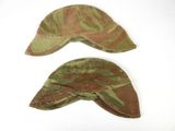 pair of camouflaged hats on a white surface with a white background