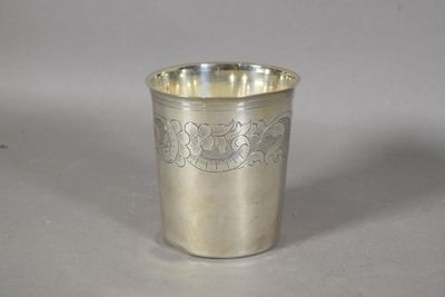 a silver cup with a design on it sitting on a table
