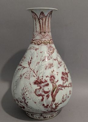 un vase blanc orné d'un motif rouge et blanc