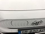 the front end of a white car parked in a parking lot