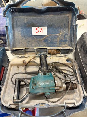 une boîte sur laquelle est posée une perceuse, dans un garage