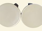 two white plates with black handles on a white surface