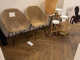 several wicker chairs and stools in a room with wood flooring