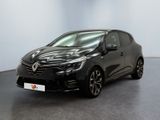 Une voiture noire est garée dans une pièce aux murs blancs.