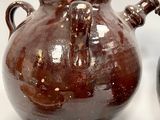 two brown vases sitting next to each other on a table