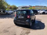 a small black car parked in a parking lot