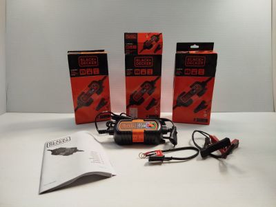 trois boîtes de piles et un chargeur posés sur une table
