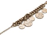 un gros plan d'un bracelet à maillons orné de pièces de monnaie