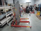 de nombreux rouleaux de tissu posés sur un chariot dans un entrepôt