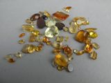 yellow and orange gems are scattered on a white surface