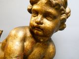 une statue en or représentant un bébé avec un oiseau sur le dos