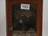 un petit meuble en bois surmonté d'une croix