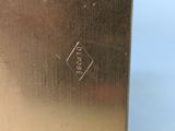 the back of a silver plate with a black diamond on it